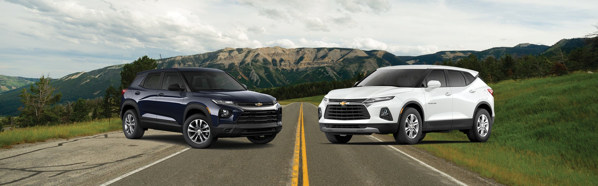 Chvey Silverodo and Colorado facing each other for compare on a road with mountains in the background.