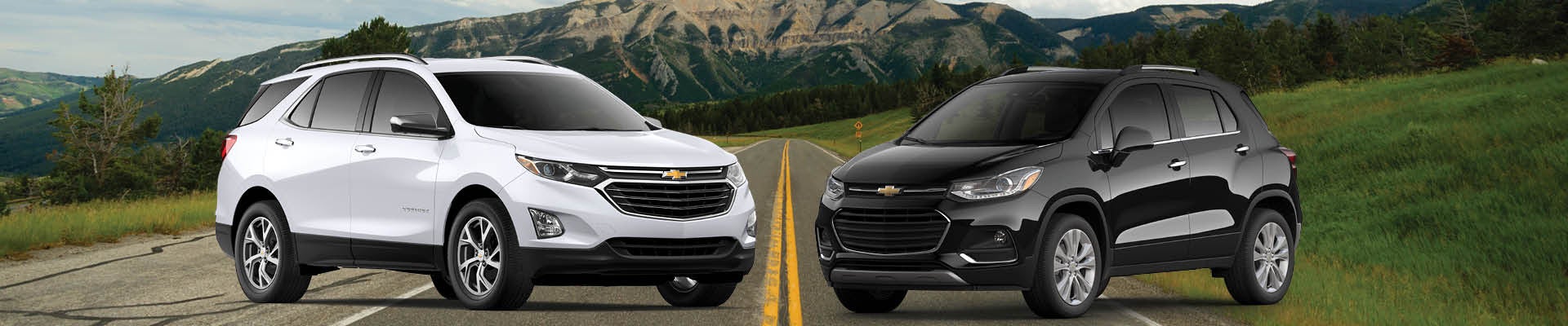 Chvey Equinox and Trax facing each other for compare on a road with mountains in the background.